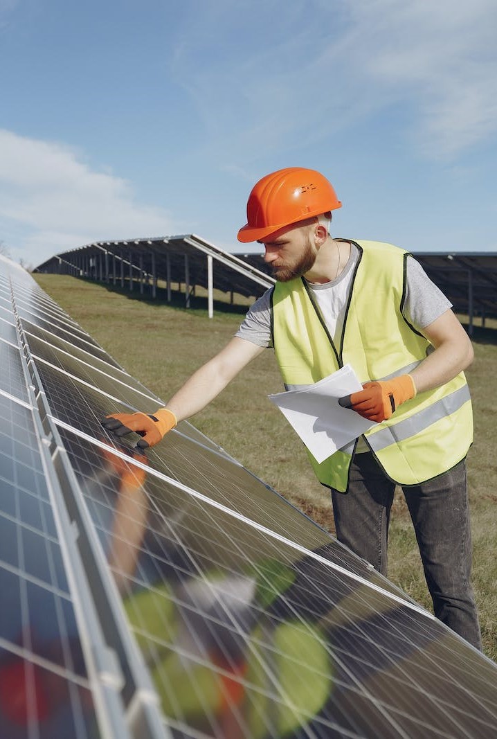 Solar Technician Inspecting Solar Panel